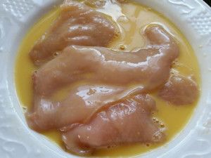 Die Hähnchenfilets trockentupfen und gründlich im Ei baden. Ja, die dürfen ruhig alle gemeinsam baden!