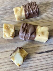 und halb oder ganz in Schokolade tunken. Auf Alufolie geben und kurz fest werden lassen.